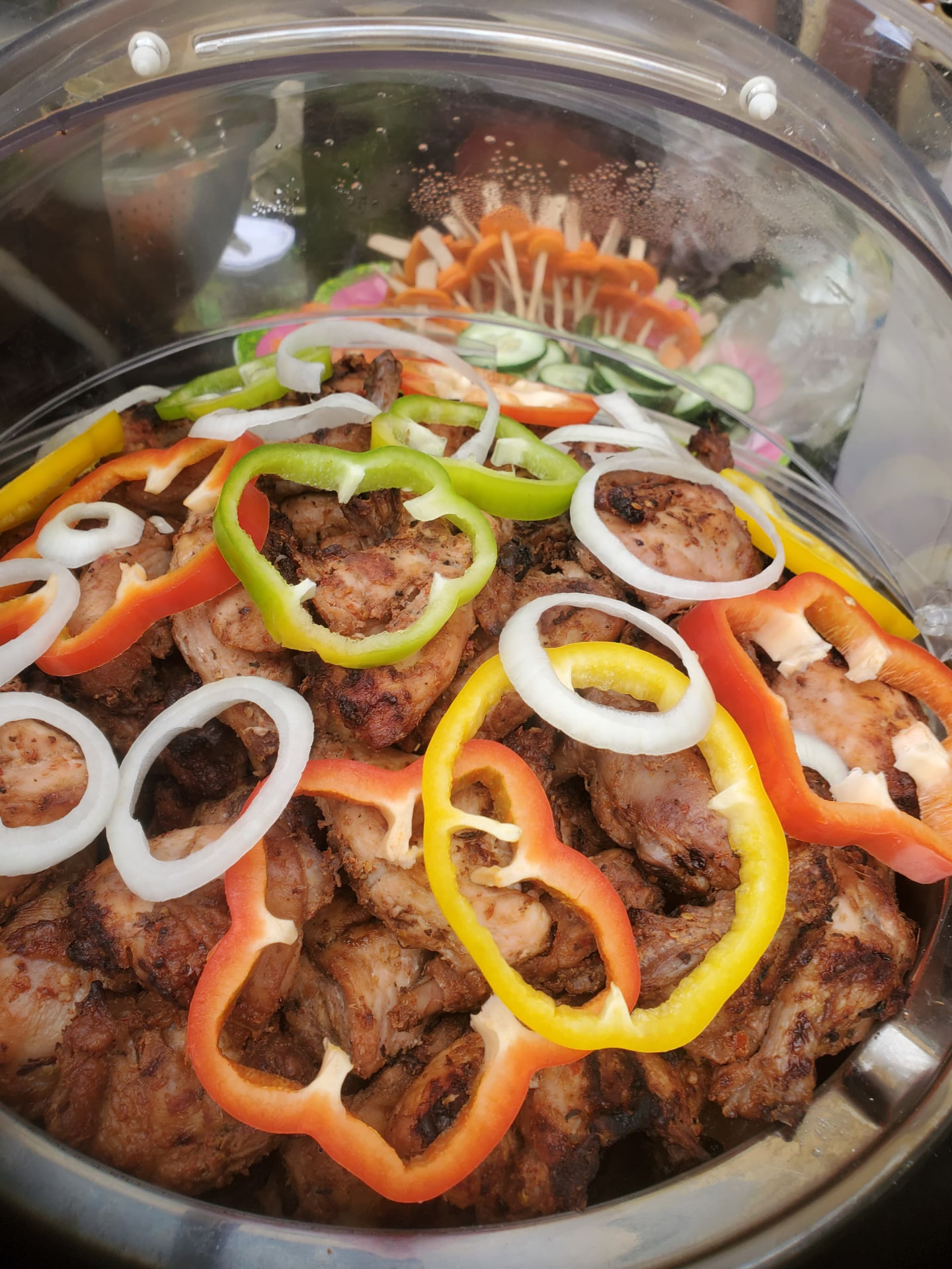 Grilled chicken and turkey platter garnished with peppers and onions